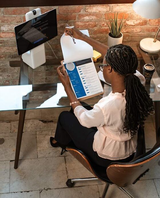 A woman sitting at her desk working on a laptop.