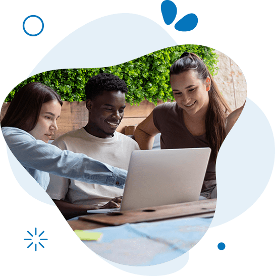 A group of people sitting around a table looking at a laptop.