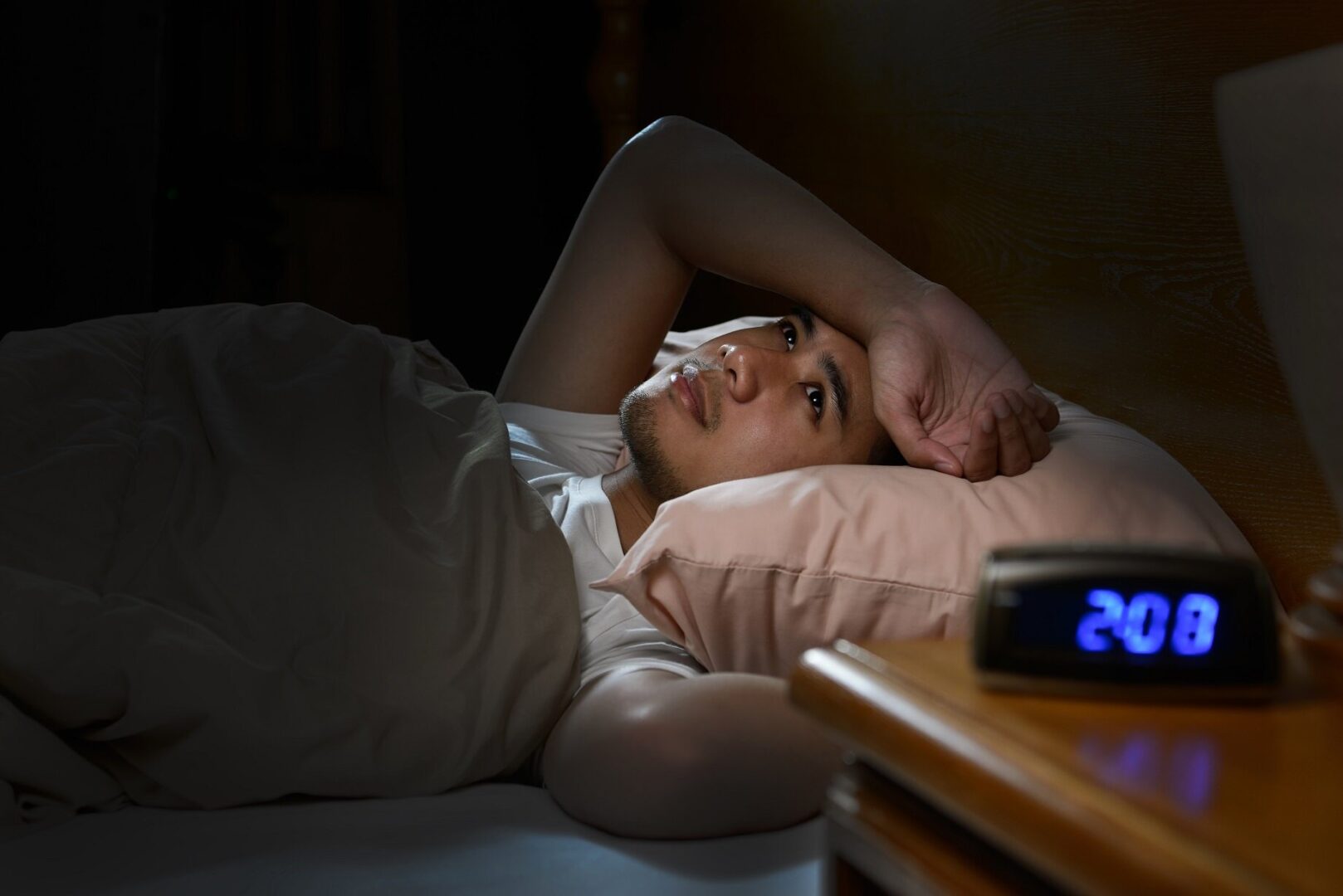 A person laying in bed with their head on the pillow.