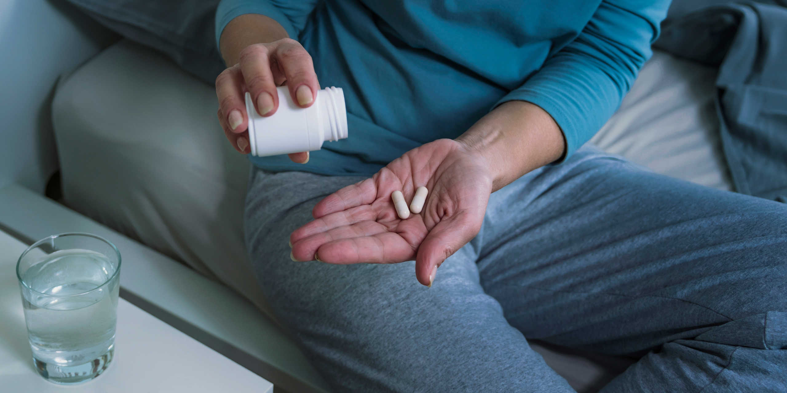 A person holding pills in their hands